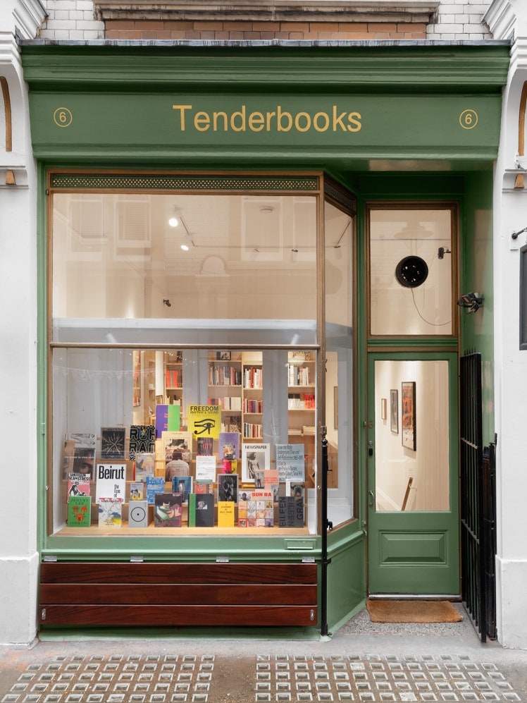 התמונה עשויה להכיל: ספר, הוצאה לאור, חנות ספרים, חנות, עיצוב הבית, שטיח, אדם, אמנות וציור