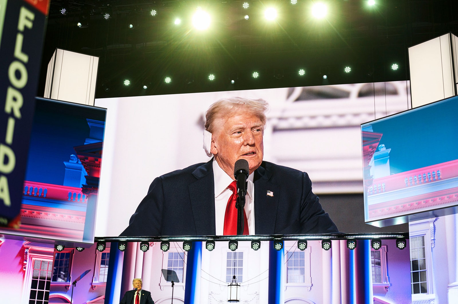 התמונה עשויה להכיל את דונלד טראמפ איש המונים מכשיר חשמלי אביזרי מיקרופון ללבוש רשמי עניבה ומבוגרים