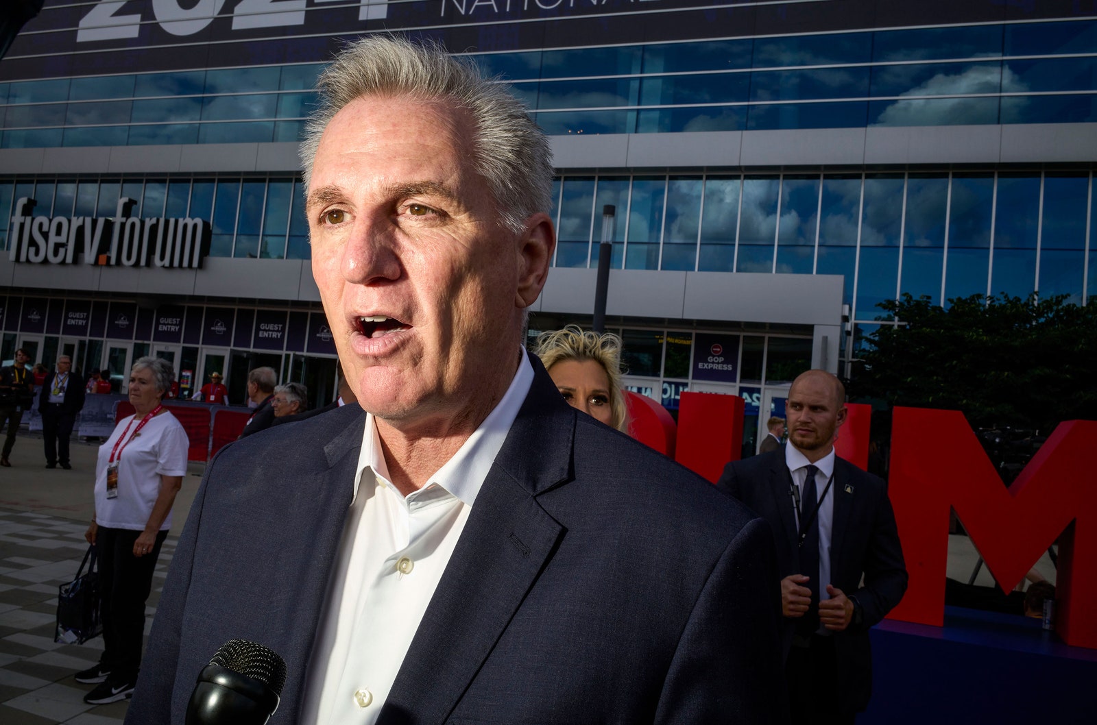 התמונה עשויה להכיל קווין מקארתי אנשים אדם קהל אביזרי תיק תיק מכשיר חשמלי מיקרופון ומבוגרים