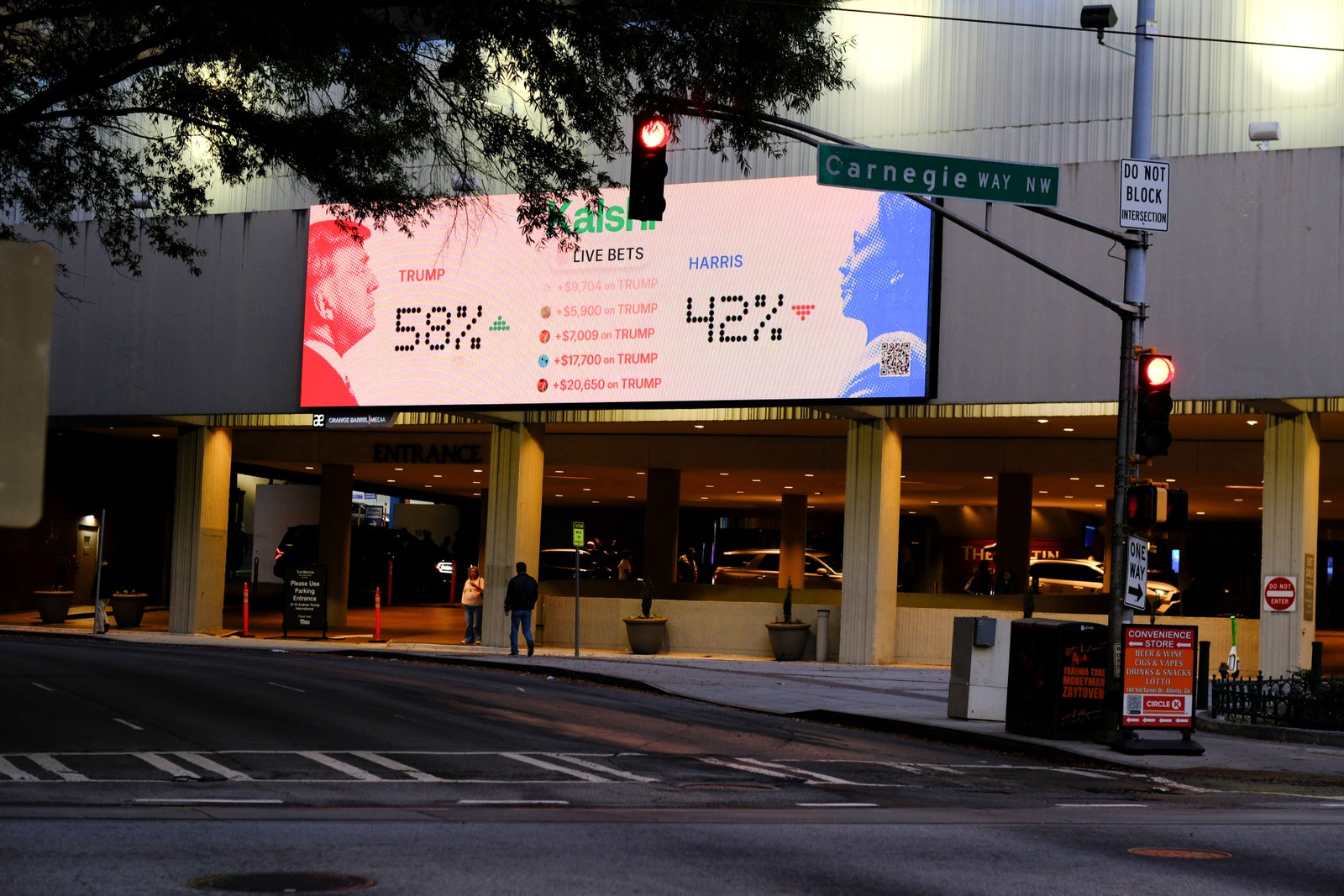 התמונה עשויה להכיל את אלכסנדרה רייט דונלד טראמפ פרסומת אור רמזור אדם צמח עיר ורכב