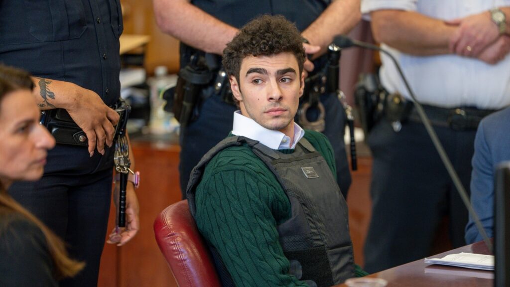 לואיג'י מנגיונה בברכה על ידי מריע, מחיאות כפיים בהופעת בית המשפט הראשון מאז מערך רצח