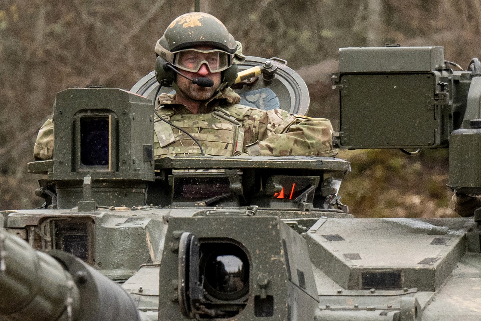 תמונה עשויה להכיל אביזרים משקפיים קסדה אדם למבוגר מכשיר חשמלי מיקרופון מדים צבאיים וצבאיים