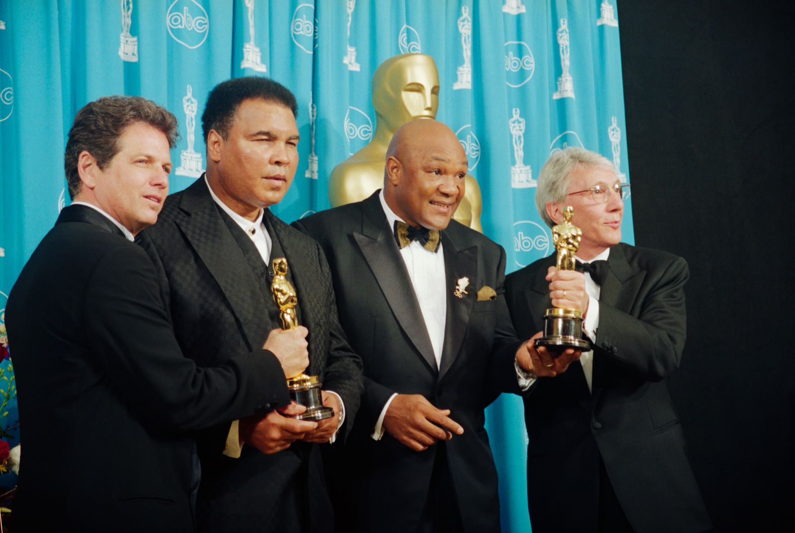 תמונה עשויה להכיל את מוחמד עלי ג'ורג 'פורמן ליאון גאסט אביזרים ללבוש רשמי אנשים אנשים מבוגרים ומשקפיים