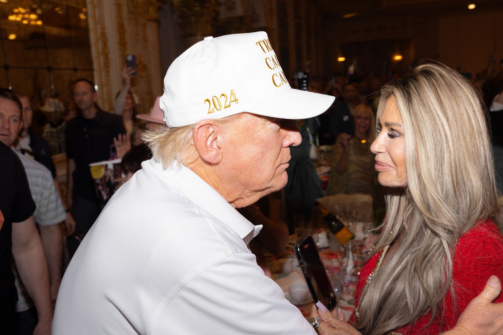 תמונה עשויה להכיל את דונלד טראמפ בגדים כובע בייסבול כובע כובע מבוגר טלפון נייד טלפון וטלפון