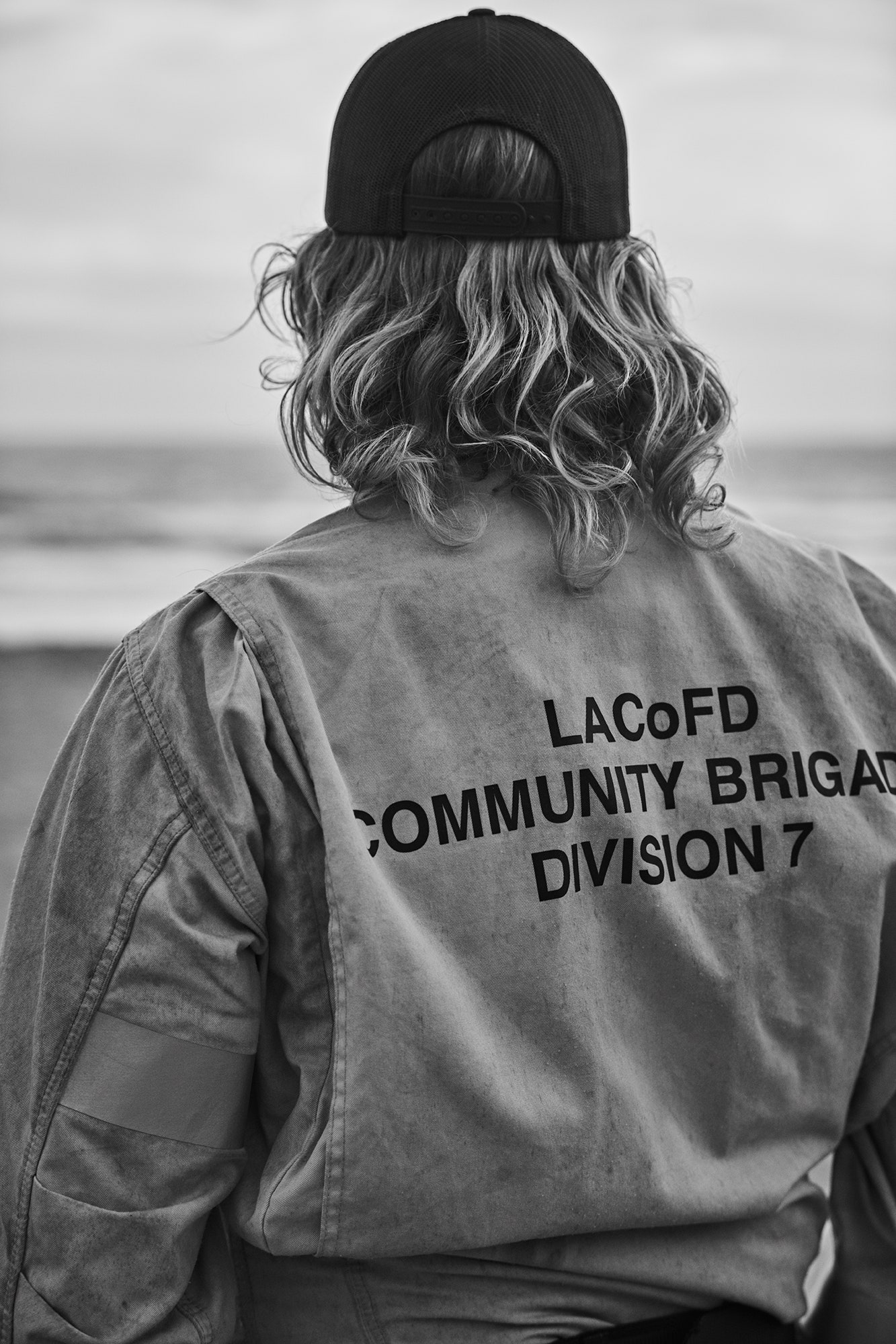 תמונה עשויה להכיל מעיל לבוש כובע כובע בייסבול כובע בייסבול אדם למבוגר גב גוף חלק גוף צילום ובלונדינית