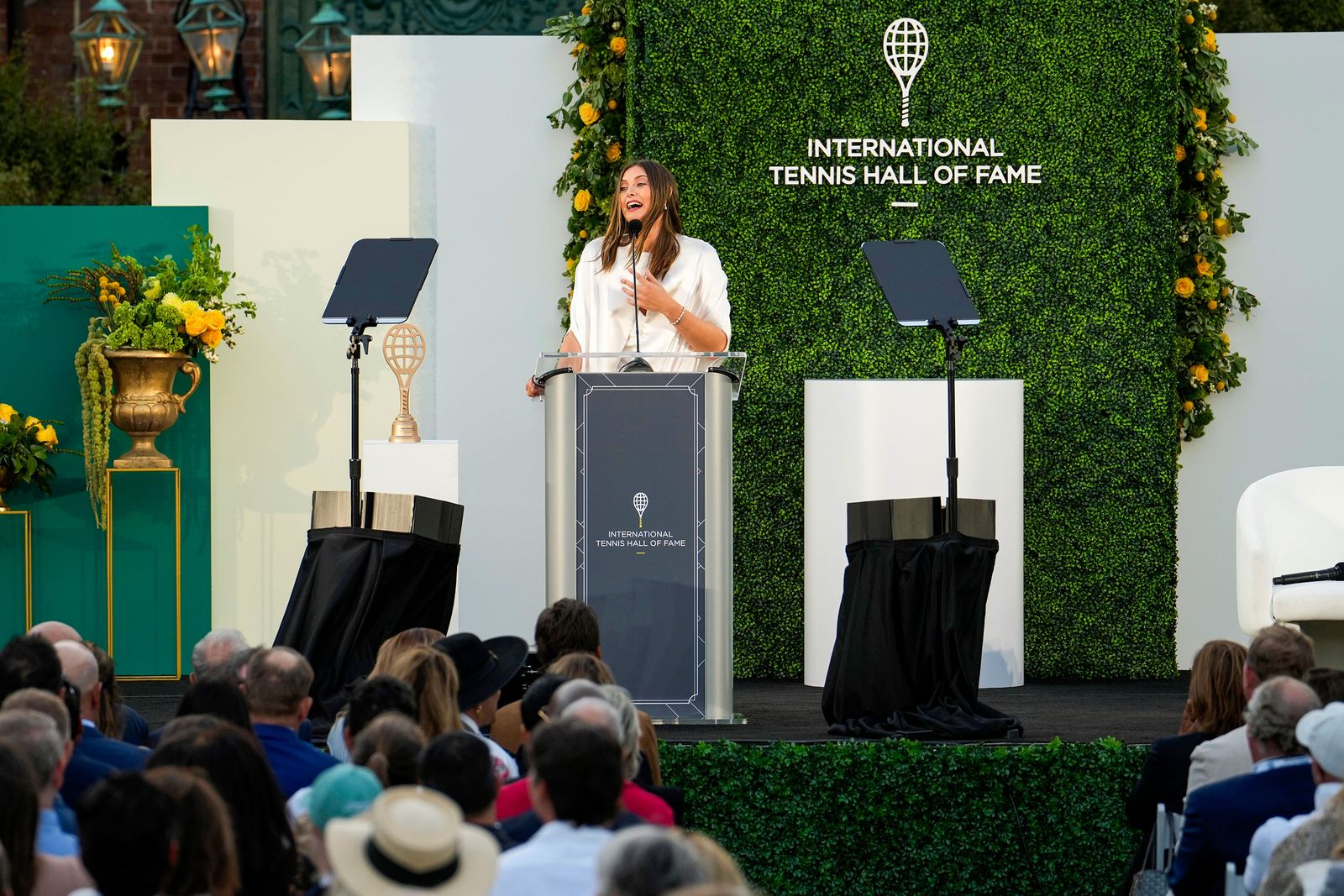 תמונה עשויה להכיל איש קהל של קהל ביגוד לבוש כובע אביזרי פודיום למבוגרים תיק ותיק יד