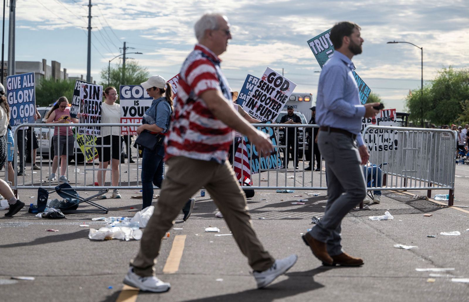 אנשים שהשתתפו באנדרטה לצ'רלי קירק עוברים על פני מפגינים.