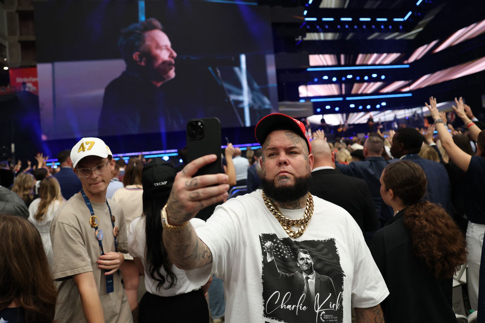 משתתף לוקח selfie בטקס האזכרה של צ'רלי קירק.