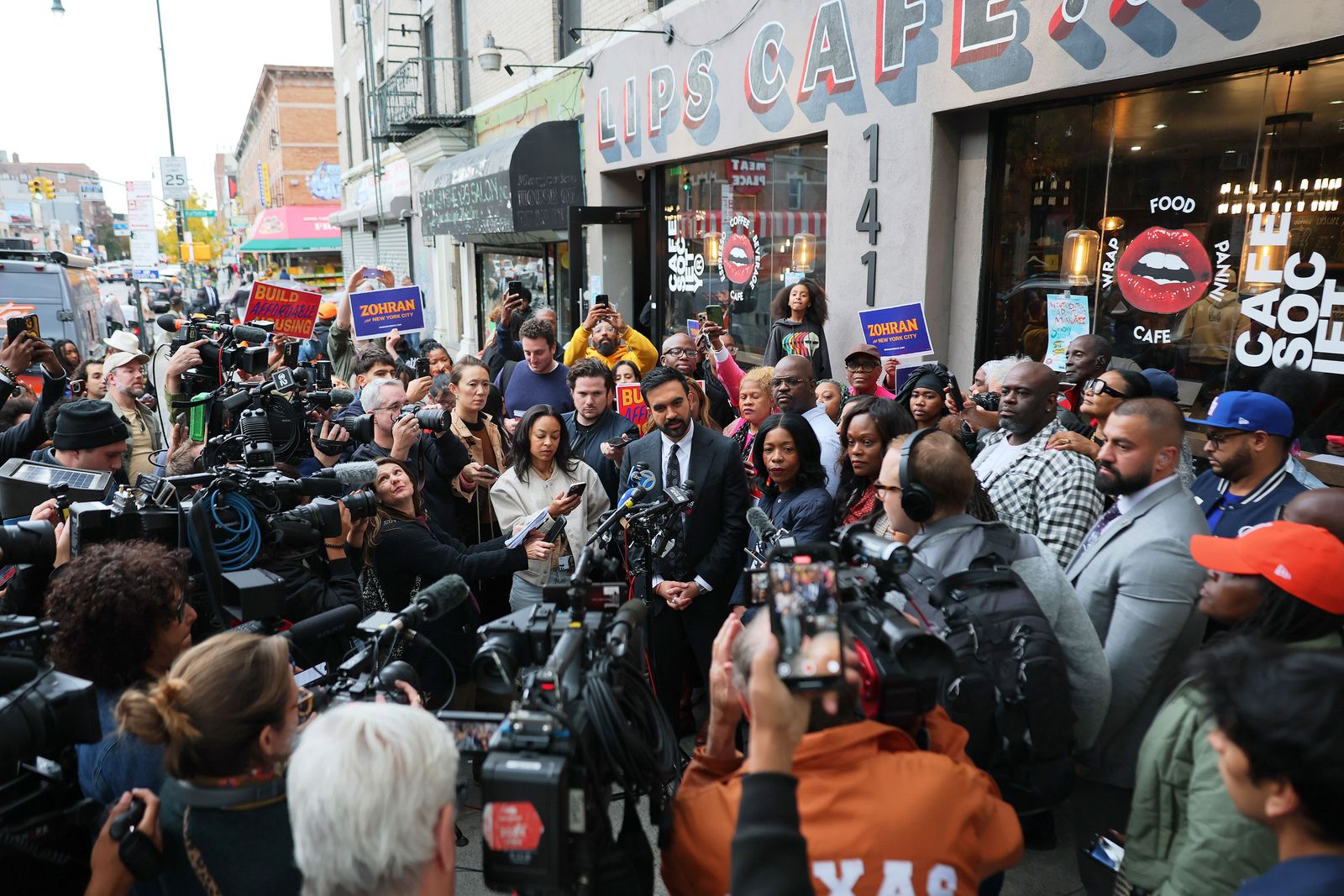 המועמד הדמוקרטי לראשות העיר, זוהרן ממדני עונה לשאלות מהעיתונות מחוץ לבית קפה במזרח פלטבוש החדש...