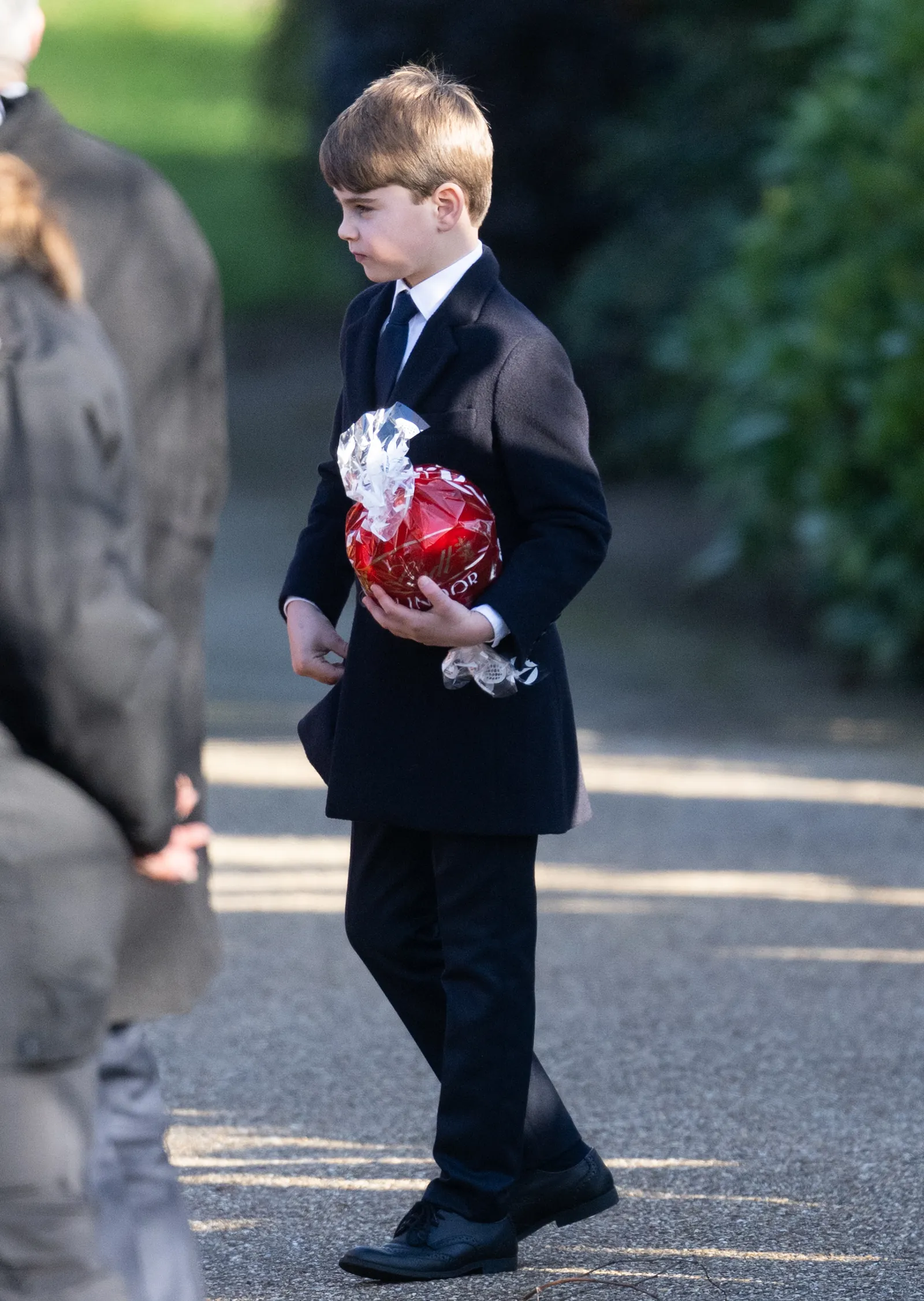 התמונה עשויה להכיל אדם הולך לבוש רשמי חליפת מעיל בלייזר מעיל ילד אביזרים ועניבה למבוגרים