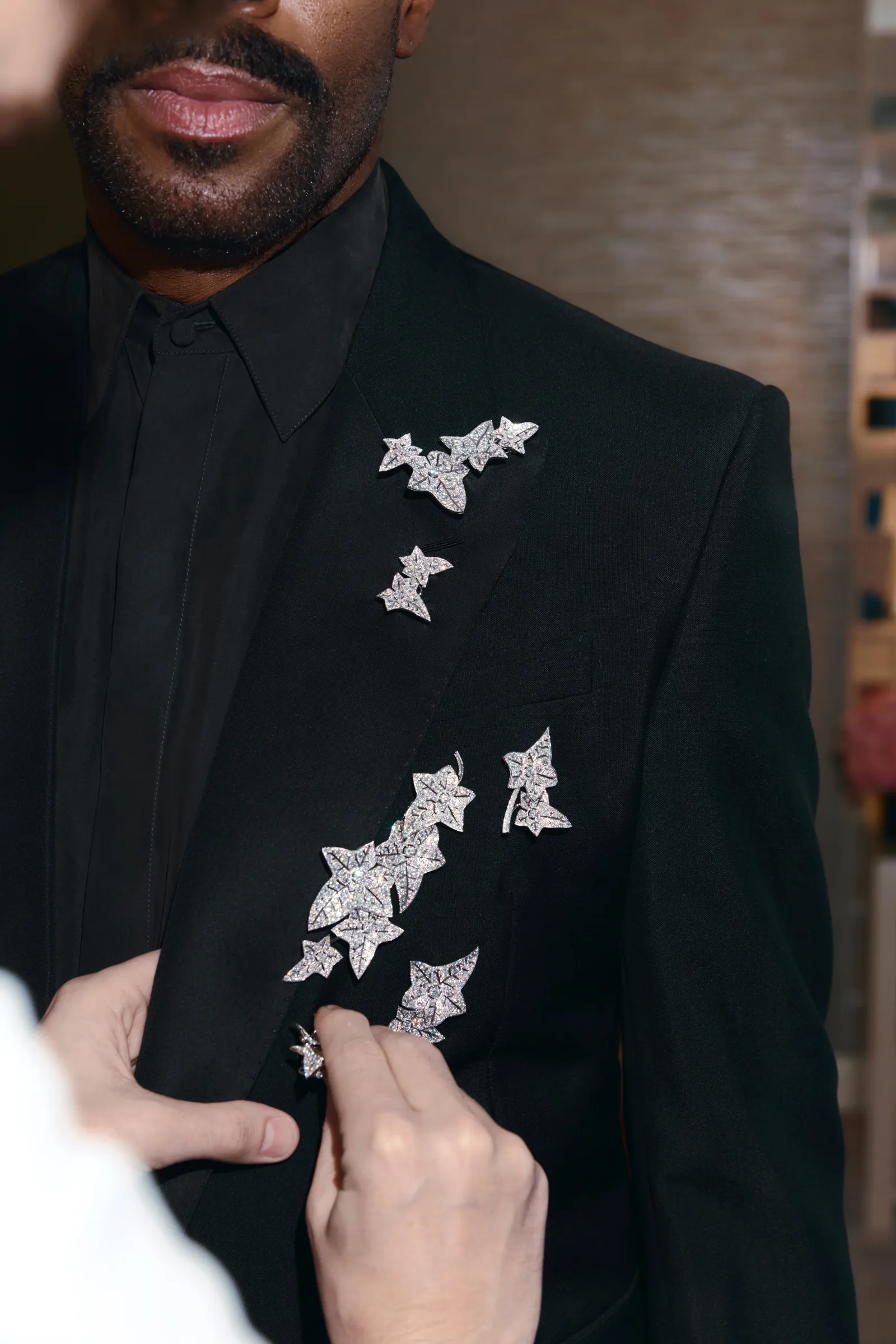 התמונה עשויה להכיל בגדים לבוש רשמי חליפת טוקסידו בלייזר מעיל מעיל אדם מבוגר אביזרים עניבה וחולצה