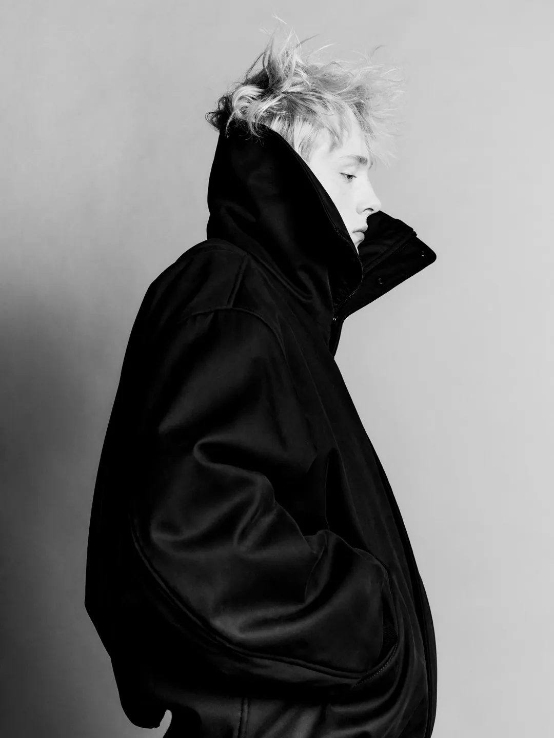 התמונה עשויה להכיל בגדים מעיל צילום אופנה אדם מבוגר פנים ראש דיוקן קפוצ'ון קפוצ'ון וסריגים