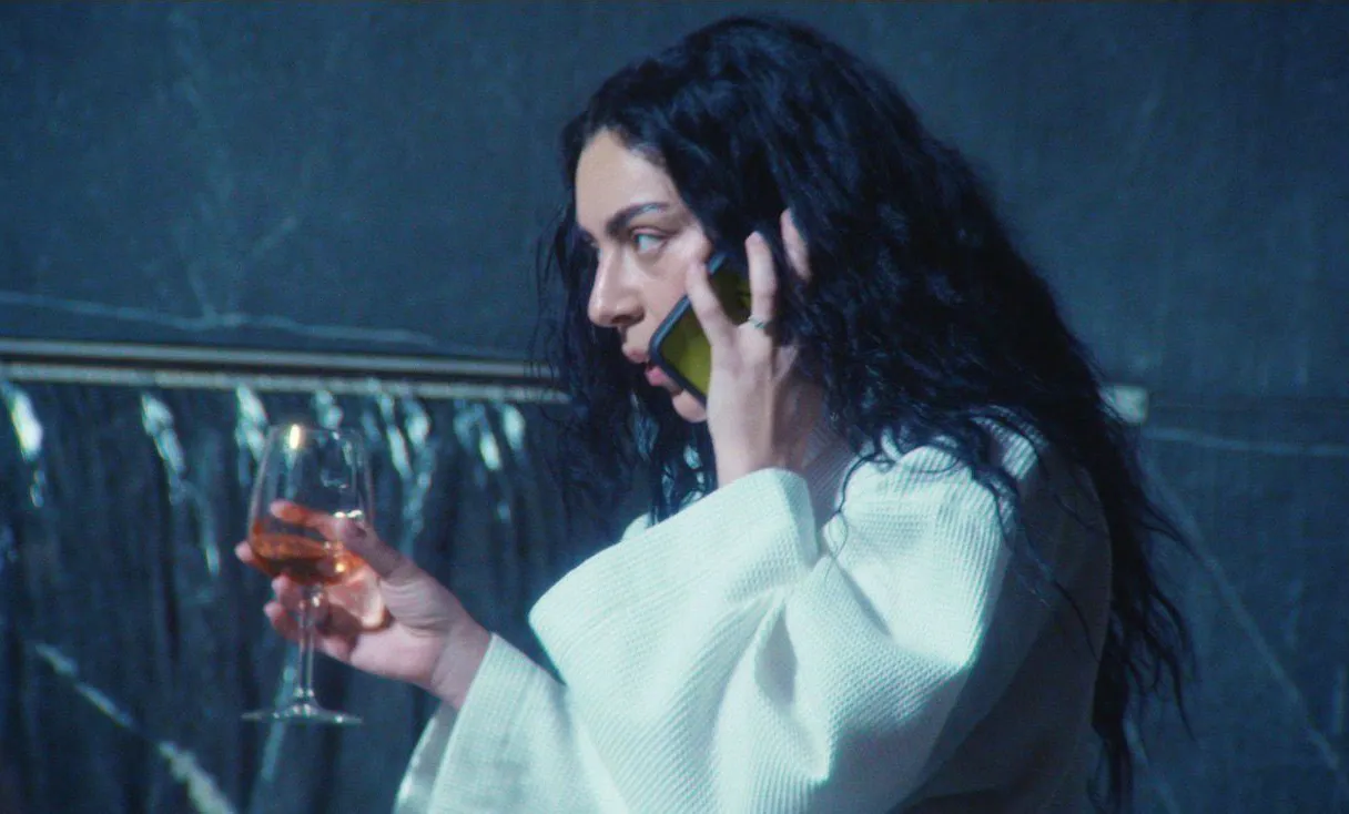 התמונה עשויה להכיל את Charli XCX Electronics טלפון נייד טלפון מבוגר צילום פנים ראש ואלכוהול