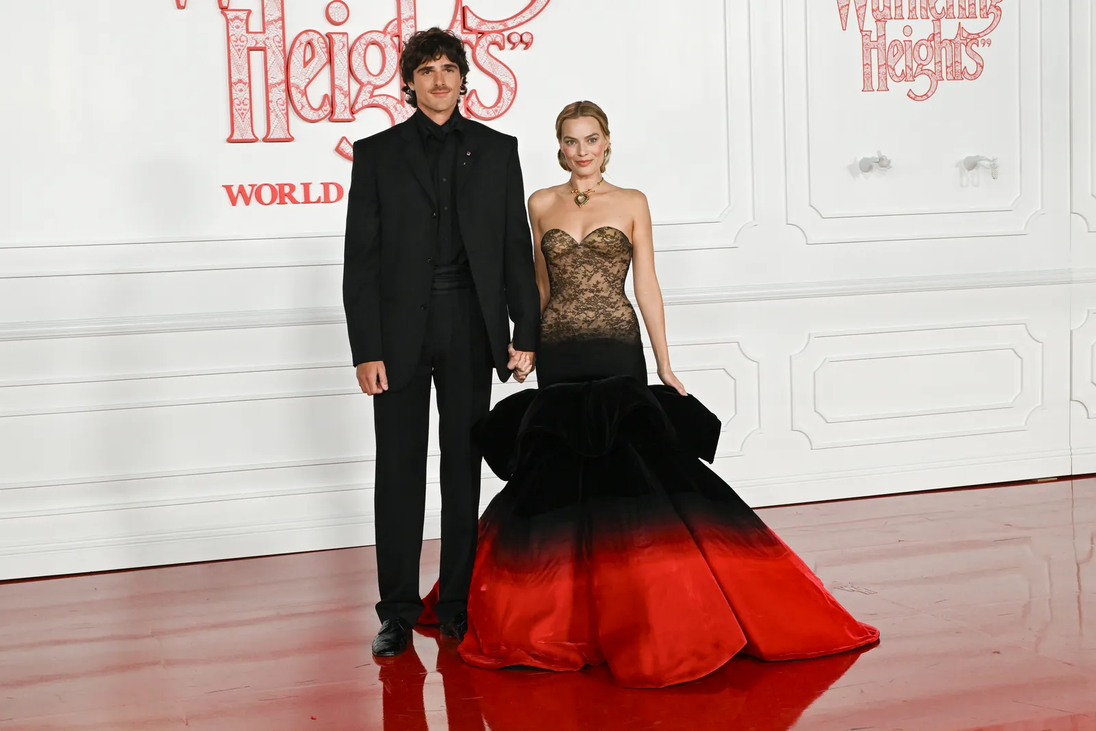 התמונה עשויה להכיל את אוליבייה מוטיס מרגו רובי בגדי אופנה שמלת לבוש רשמי חליפה ומעיל לאדם מבוגר