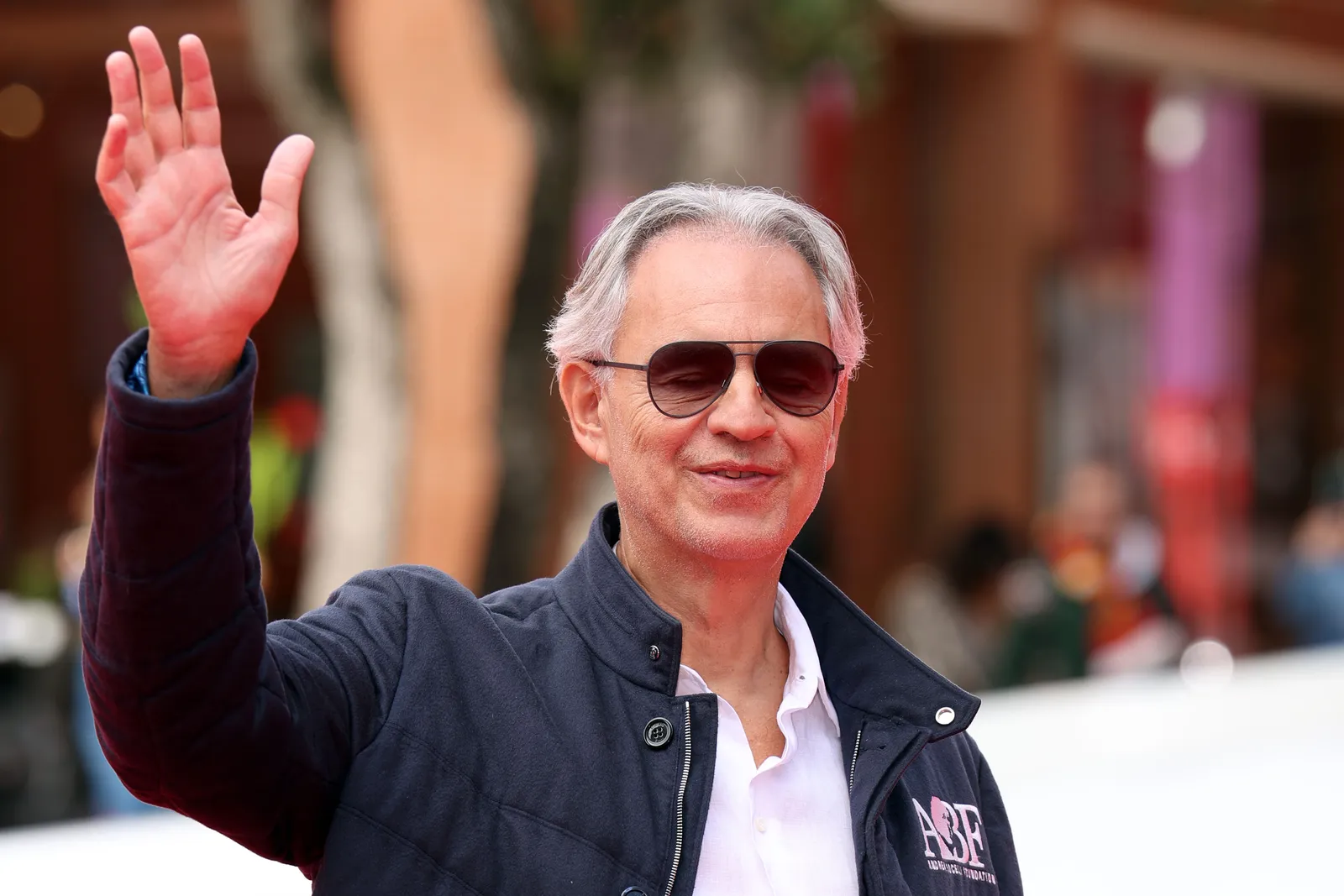 התמונה עשויה להכיל את אנדריאה בוצ'לי שיער בלונדיני אביזרים לאדם משקפי שמש צילום פנים ודיוקן