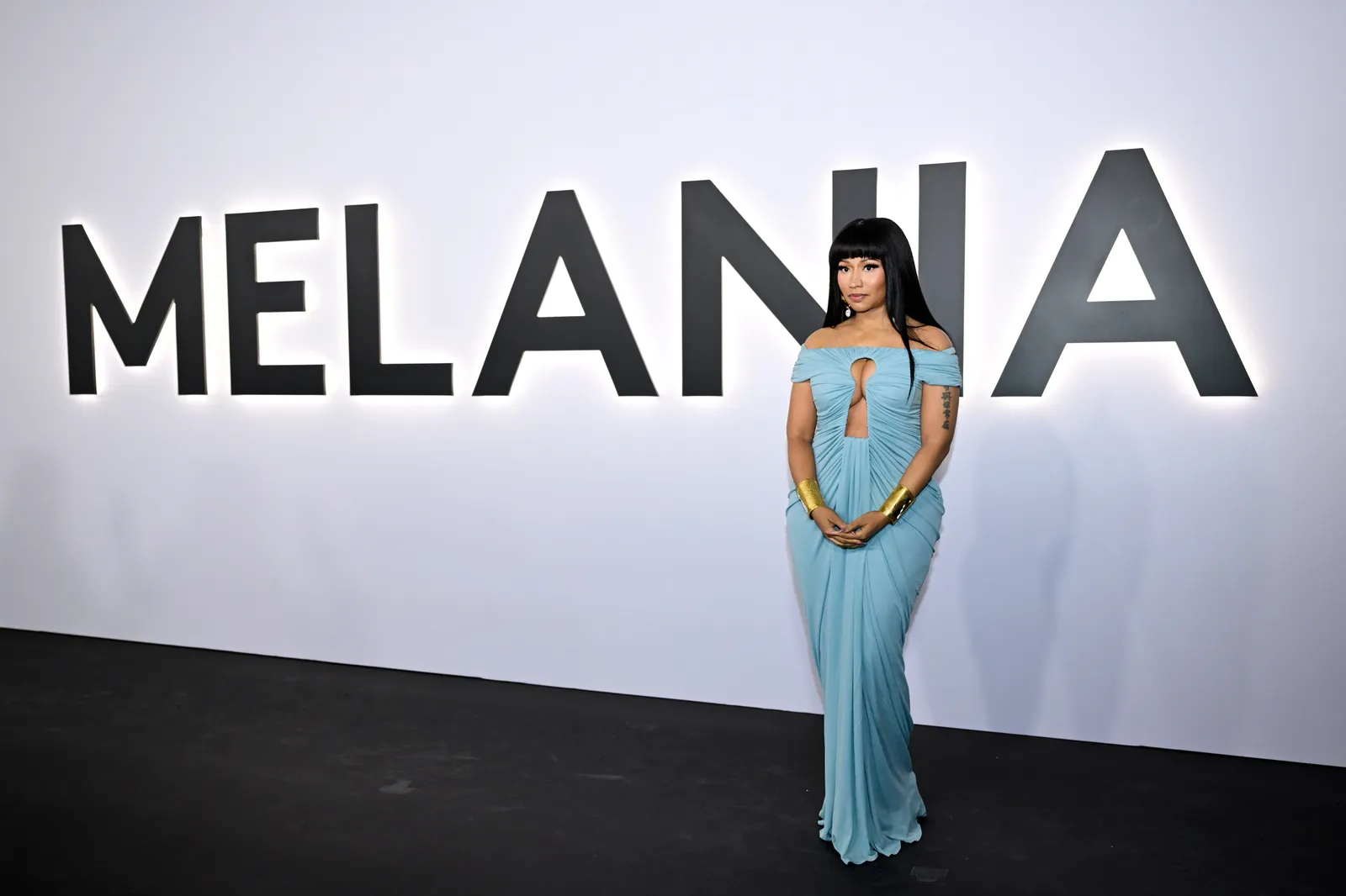 התמונה עשויה להכיל ניקי מינאז' שיער שחור שיער אדם בגדי שמלה למבוגרים לבוש רשמי שמלת ערב ואופנה