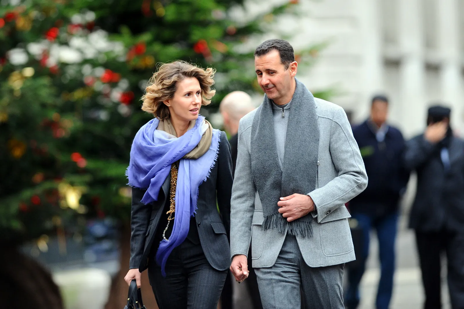 התמונה עשויה להכיל את בשאר אל-אסאד אסמה אל-אסד אדם בגדי מבוגרים מעיל צעיף בלייזר וז'קט