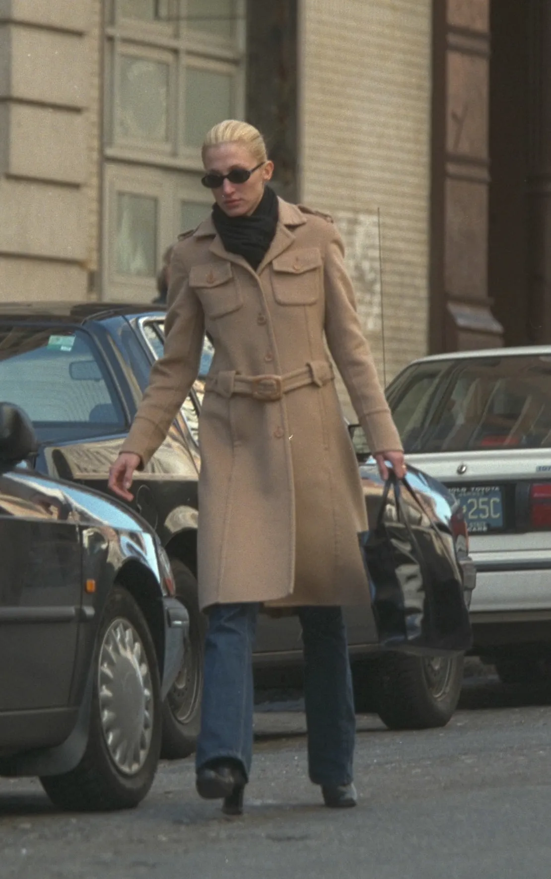 התמונה עשויה להכיל את Carolyn Bessette קנדי ​​ביגוד מעיל אדם מעיל על אביזרים תיק משקפיים תיק יד ומבוגרים