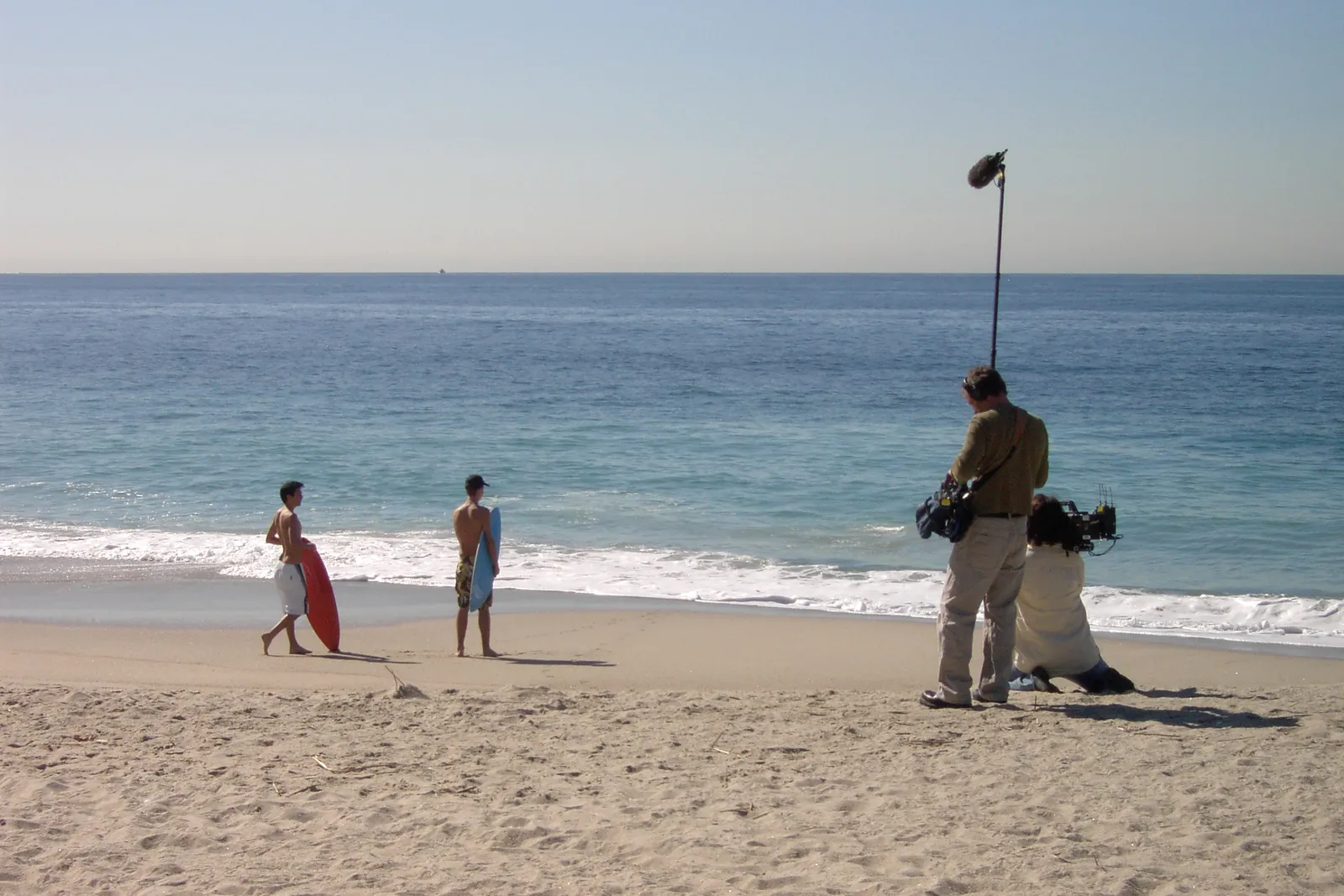 התמונה עשויה להכיל חוף חוף טבע בחוץ ים קו חוף צילום מים בגדים מכנסיים קצרים אדם והליכה