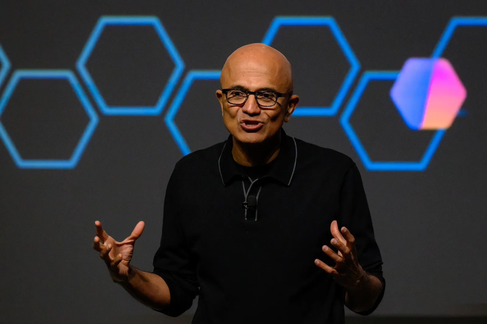 התמונה עשויה להכיל את Satya Nadella חלק גוף אצבע יד אדם מבוגרים אנשים עם פנים ראש מבצע וביצועי סולו