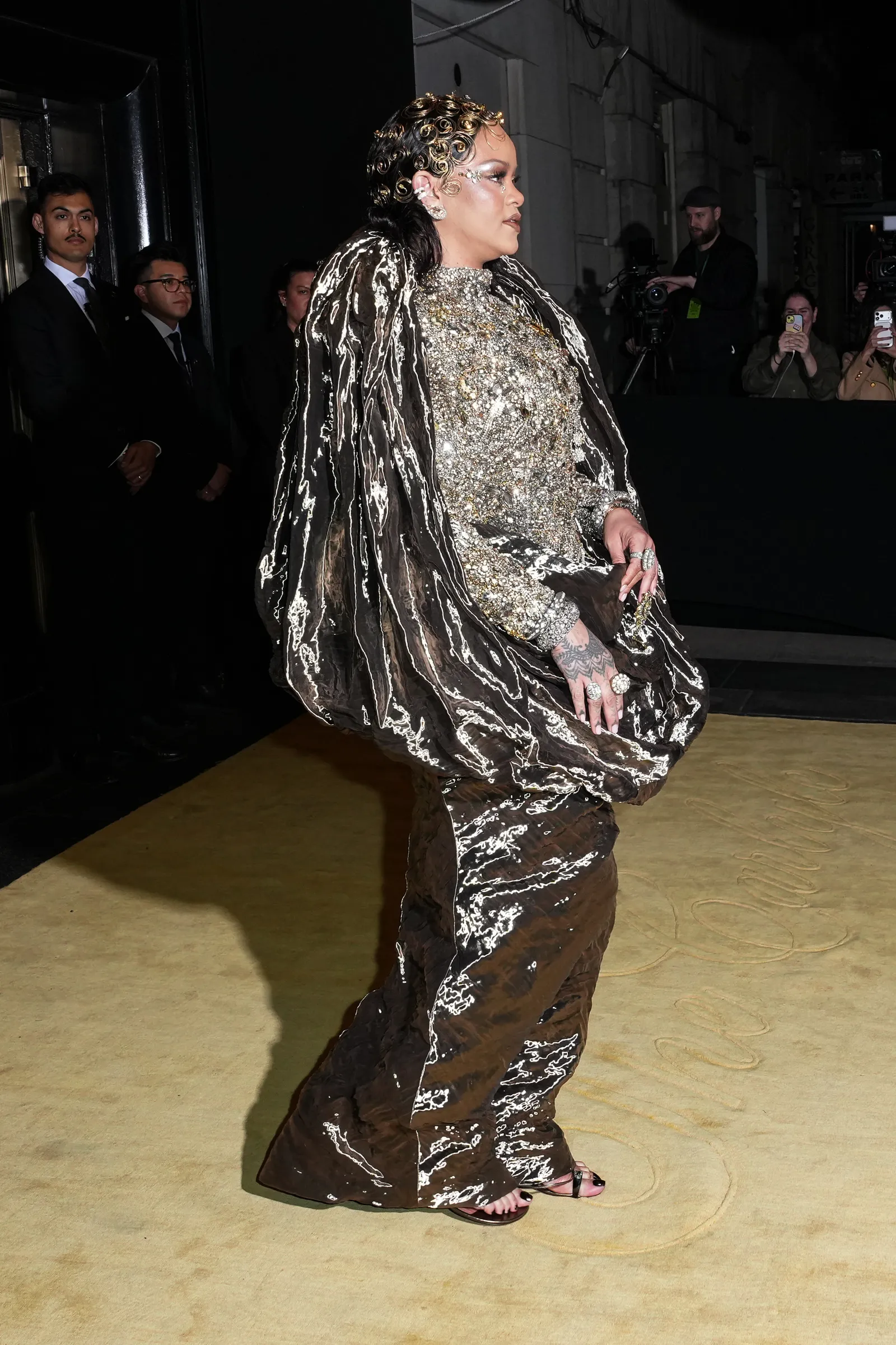 התמונה עשויה להכיל Rihanna אופנה אדם ביגוד שמלה אביזרי תיק תיק לבוש רשמי למבוגרים ומבצע