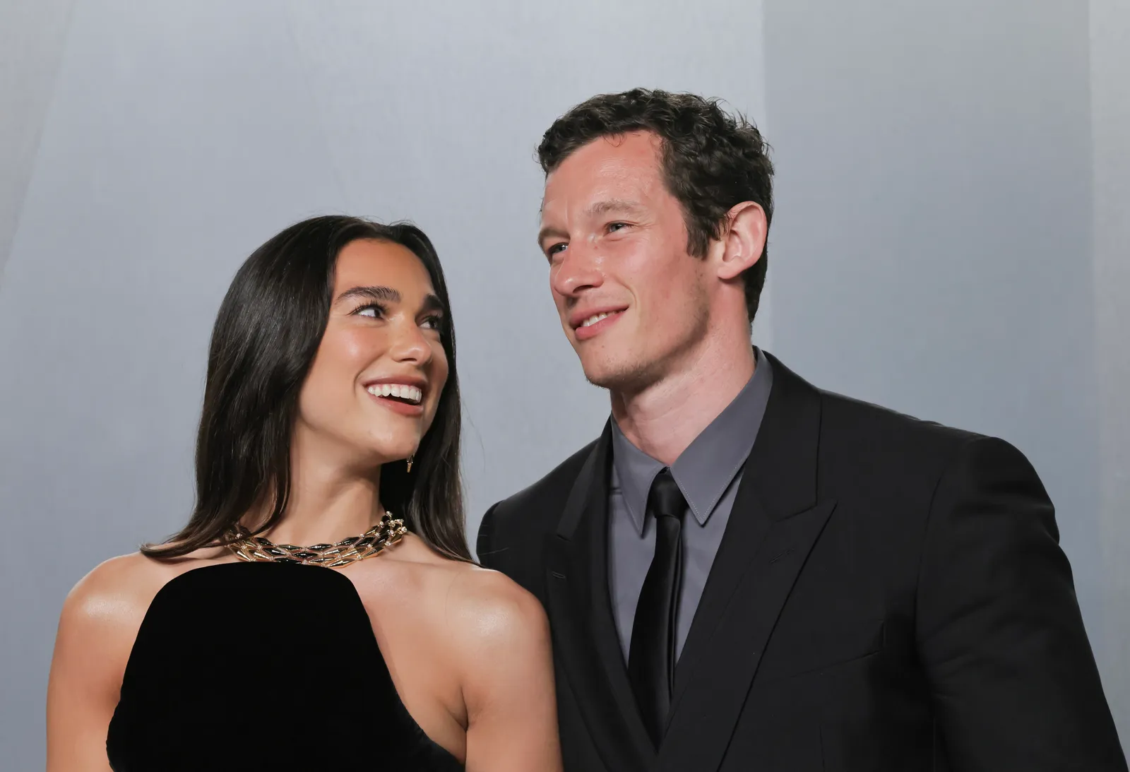 התמונה עשויה להכיל את Callum Turner Dua Lipa ביגוד חליפת לבוש רשמי פנים שמח ראש אדם חיוך ומבוגרים