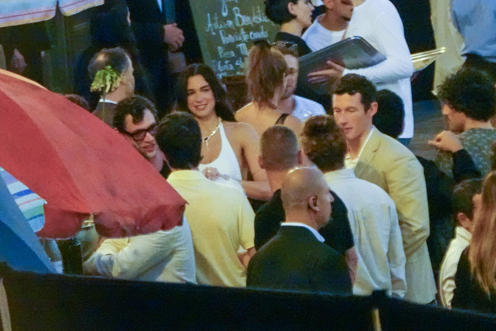 התמונה עשויה להכיל את Callum Turner Dua Lipa אדם מבוגר אנשים חתונת Photobombing ראש פנים ואביזרים