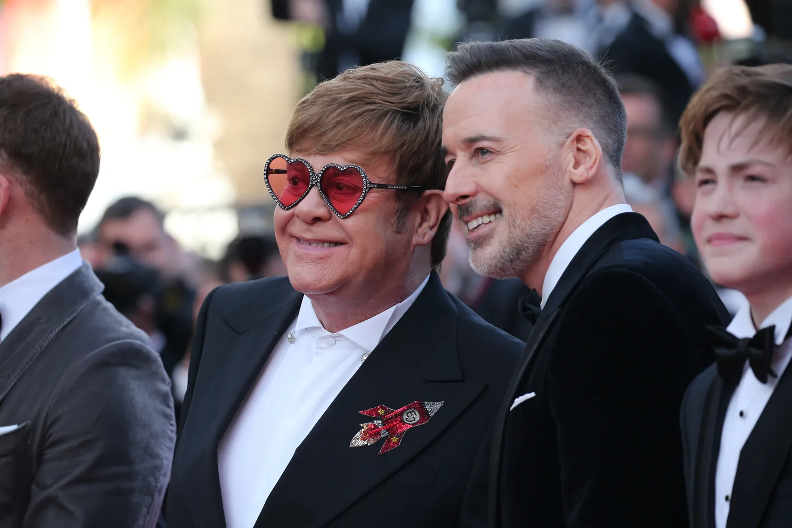 התמונה עשויה להכיל את David Furnish אלטון ג'ון בלייזר ביגוד מעיל מעיל פנים ראש צילום ודיוקן